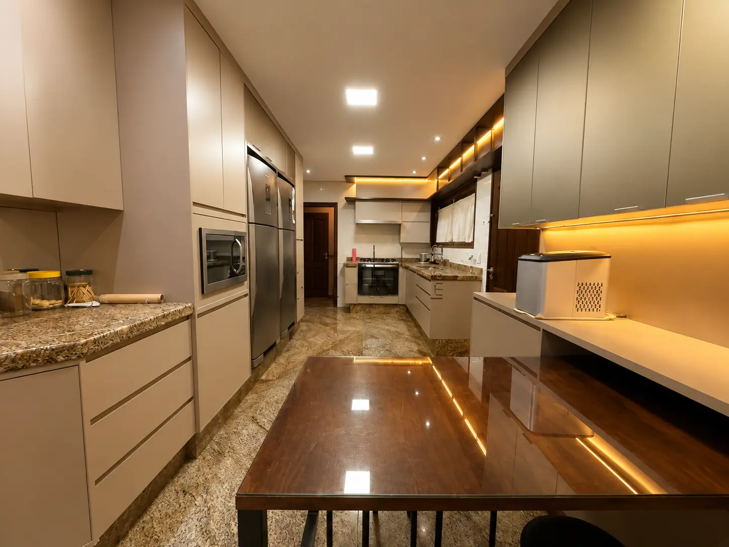 Cozinha interna planejada com ilha e iluminação embutida