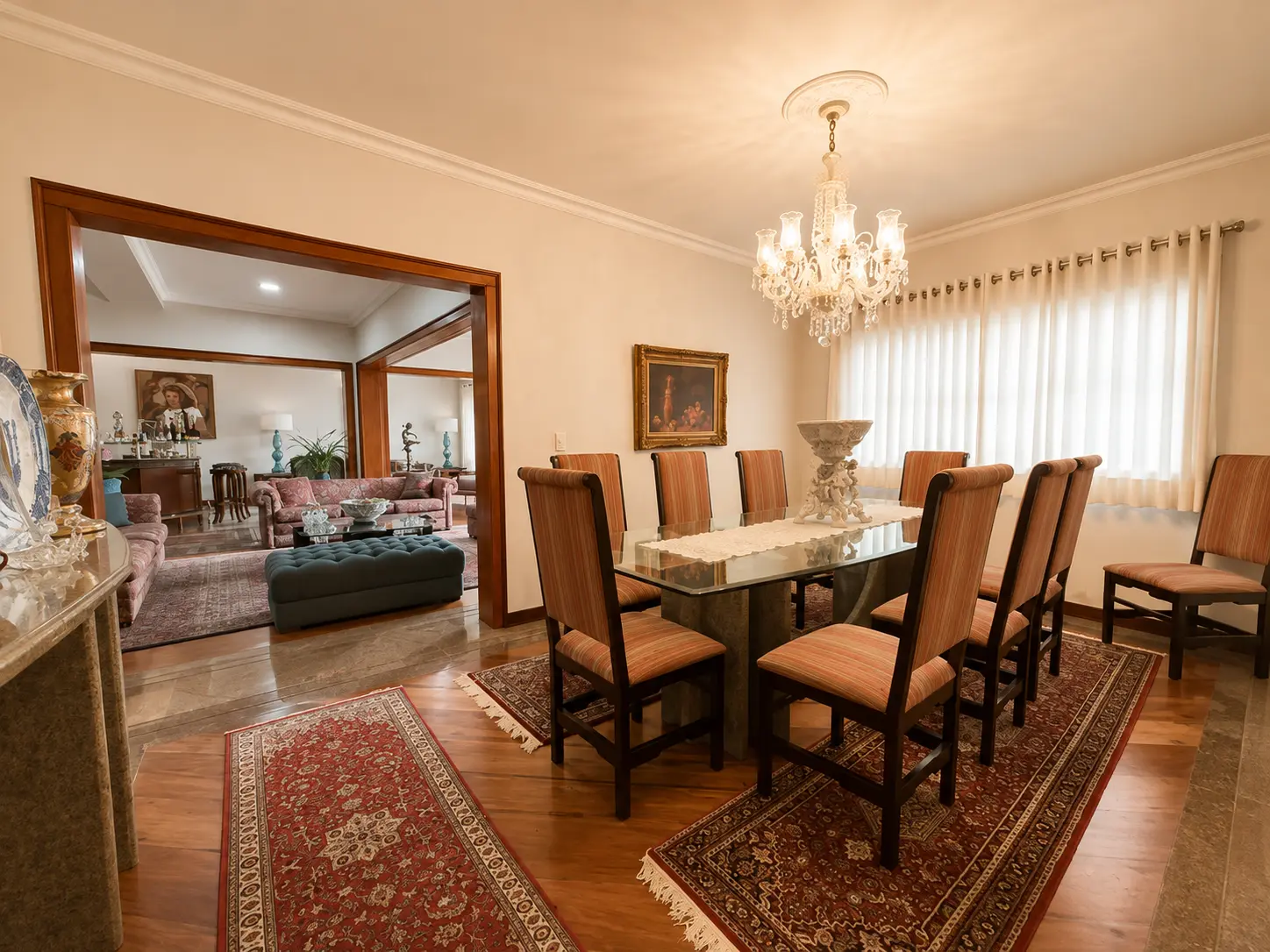 Sala de jantar com lustre de cristal e mesa para oito lugares