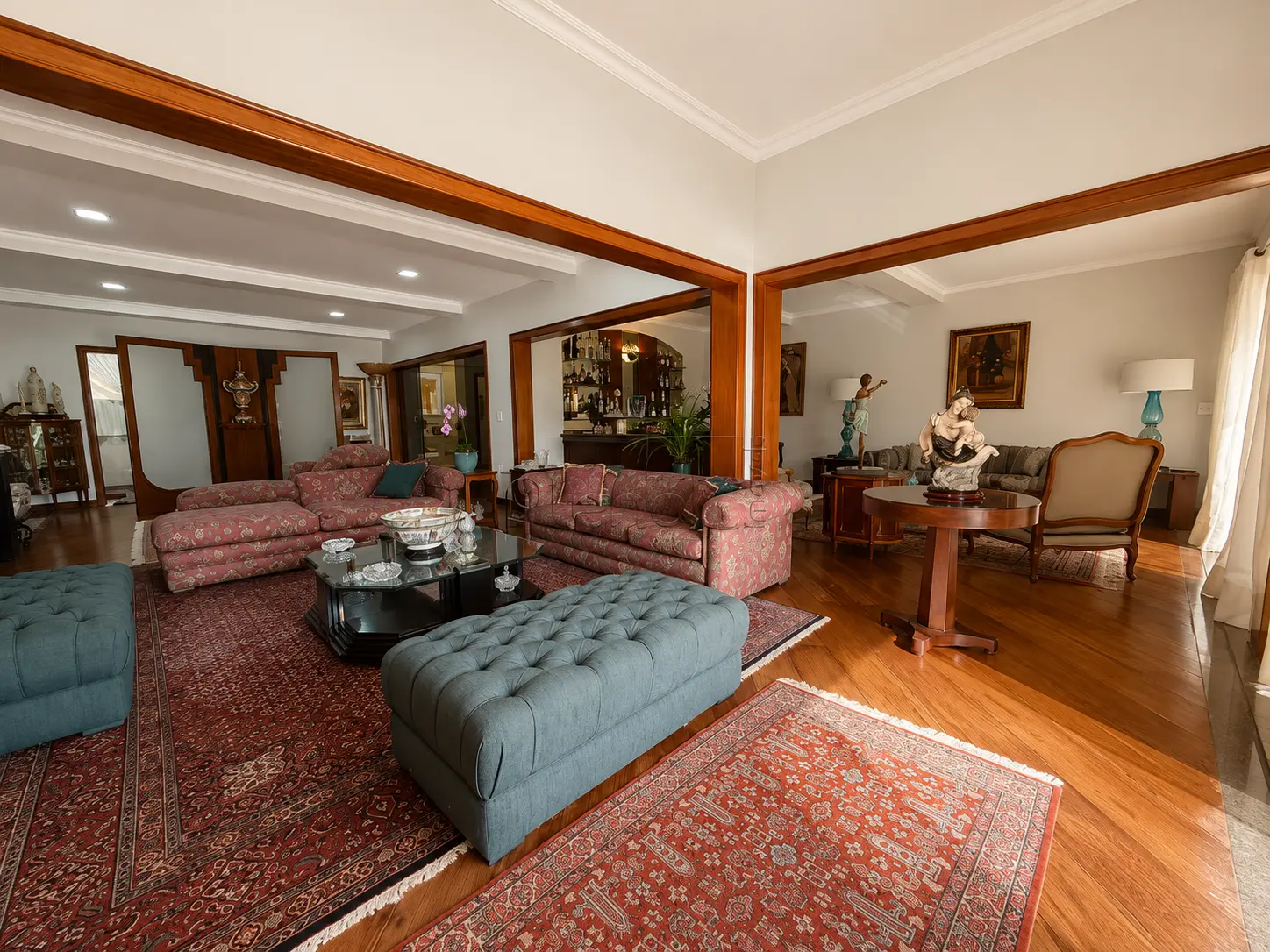 Salas de estar integradas com bar e piso em madeira