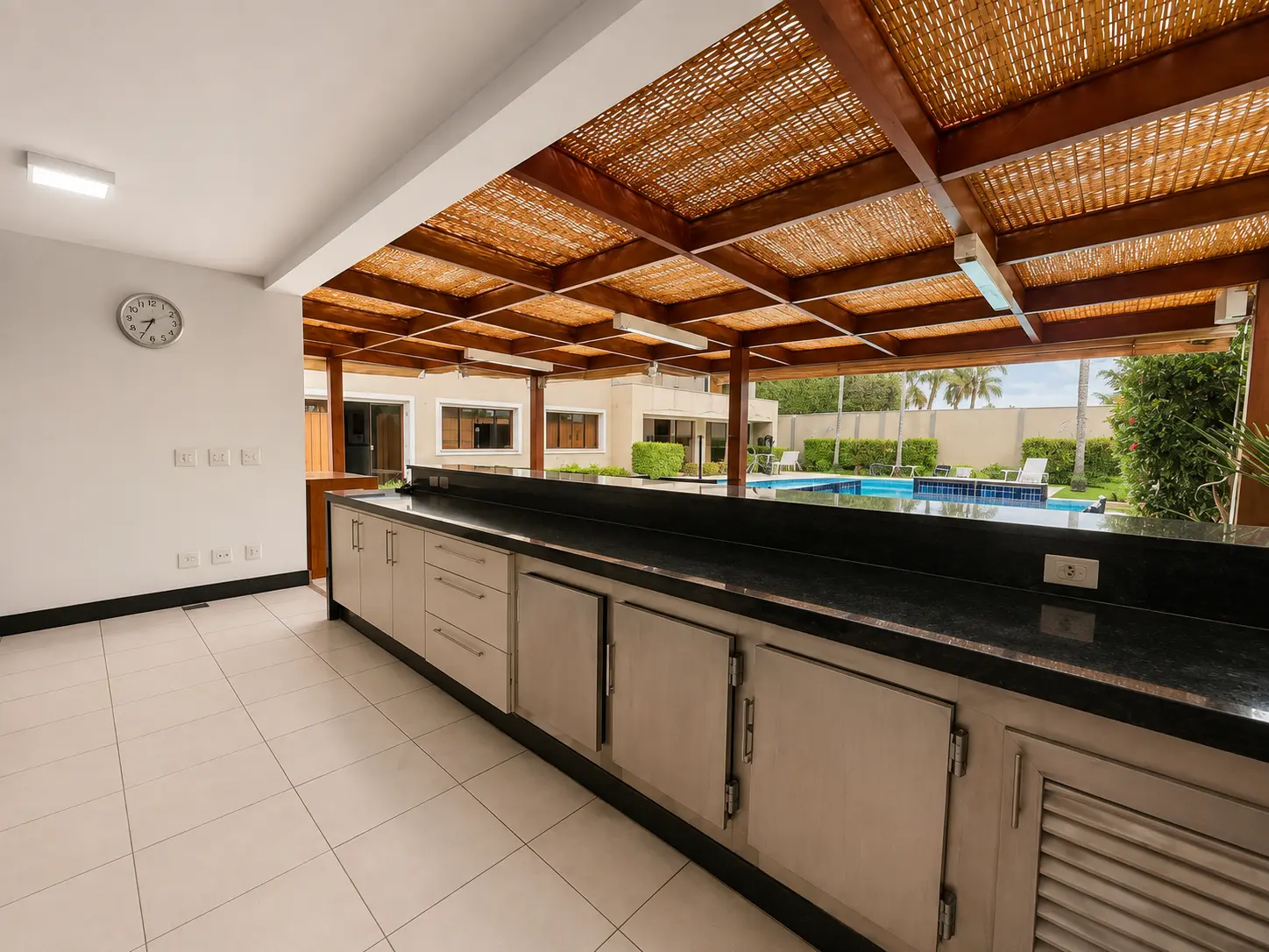 Bar com bancada em granito e vista para a piscina