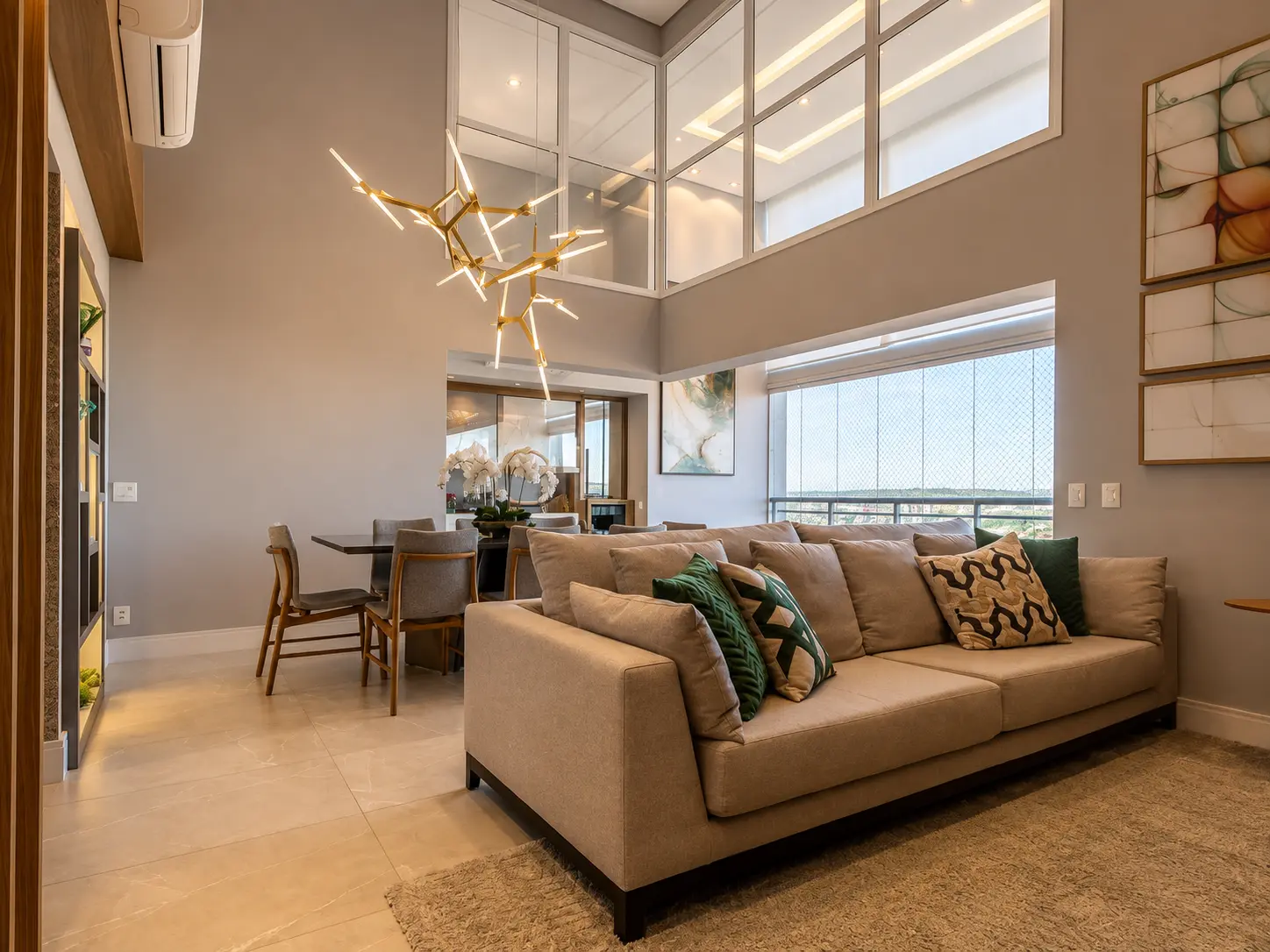 Living com sofá amplo, jantar ao fundo e vista panorâmica